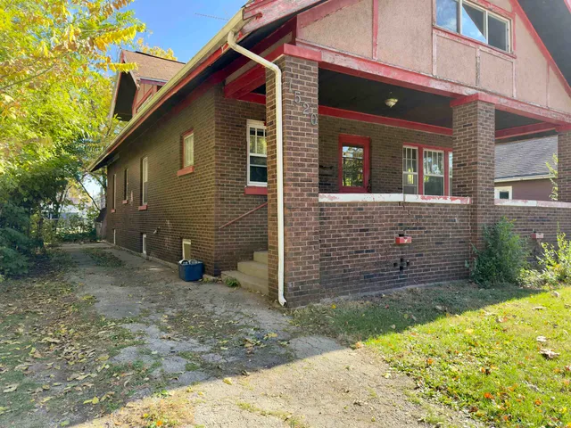 a view of brick house with small yard