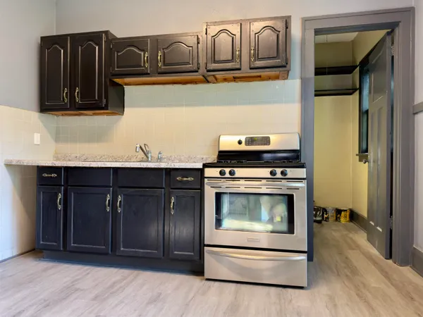 a kitchen with granite countertop a stove and a microwave
