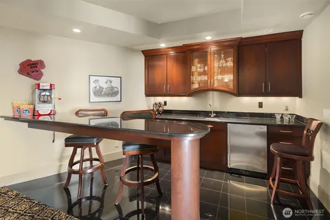 a kitchen with granite countertop a stove a sink and a refrigerator