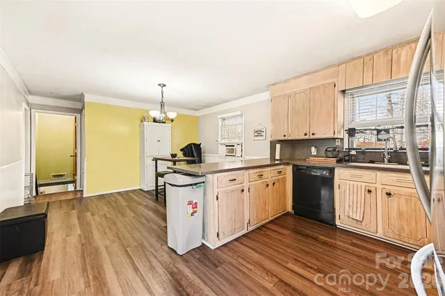 a kitchen with granite countertop a stove a sink and a refrigerator