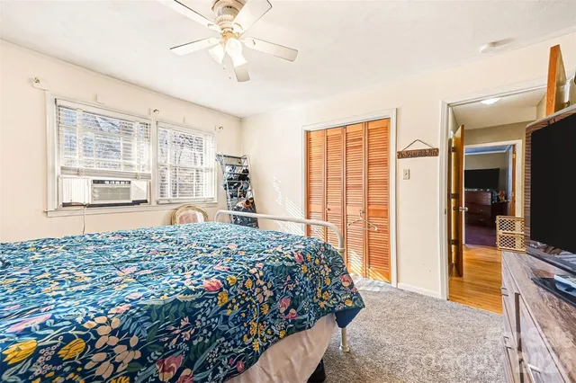 a bedroom with a bed mirror and a window