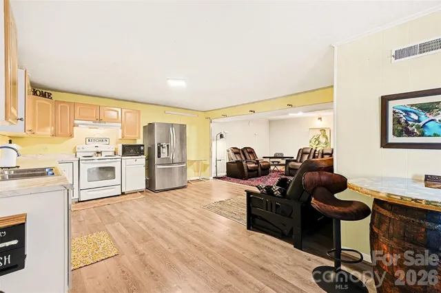 a living room with furniture stove and a large window