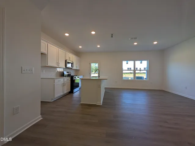 a view of a kitchen with microwave and refrigerator