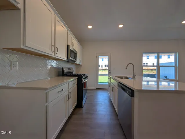 a kitchen with stainless steel appliances granite countertop lots of counter top space and stove top oven