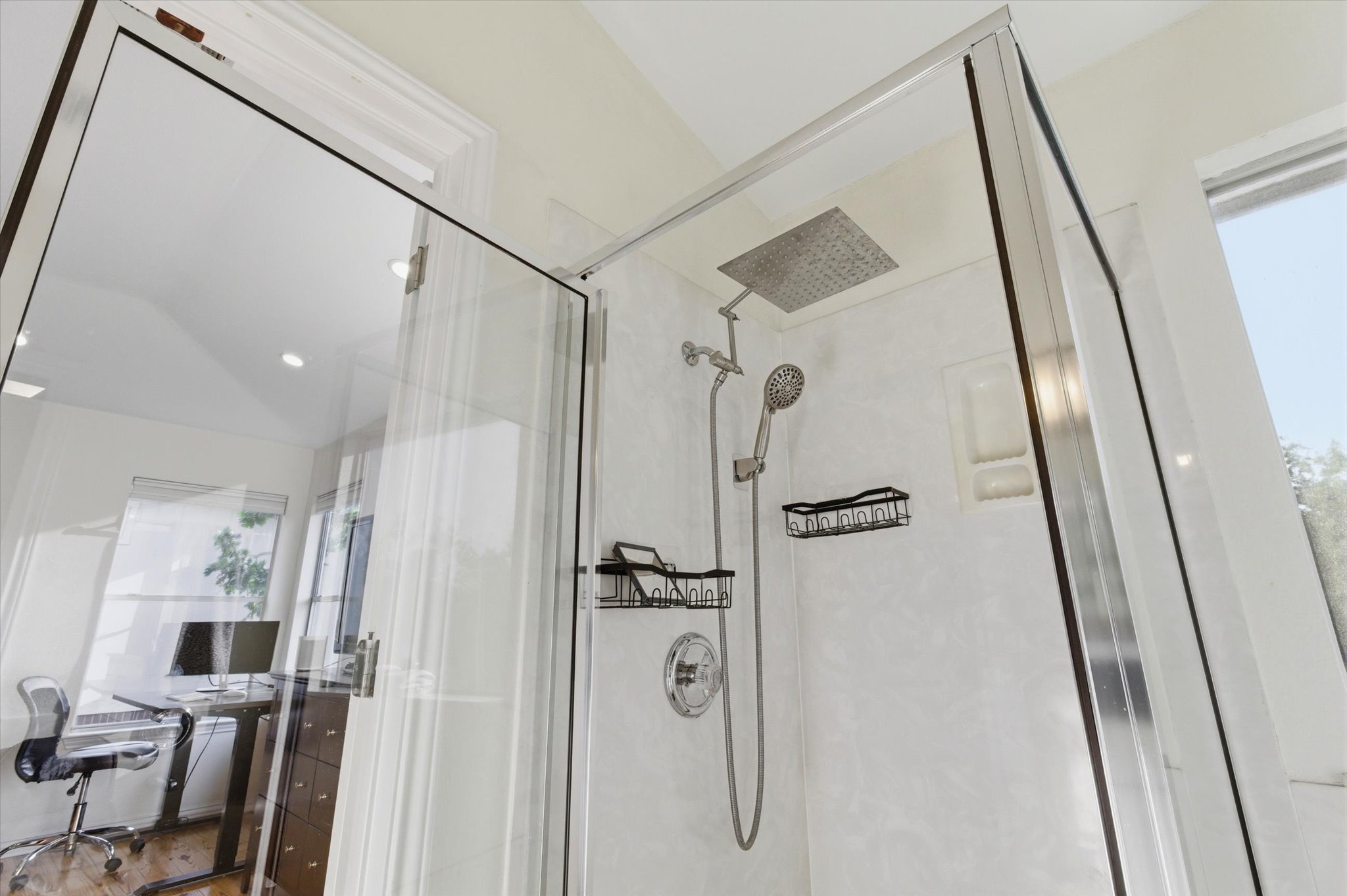 8920 West Hove Loop Austin, TX 78749 - Photo 15 of 39 Glass-enclosed shower featuring a rainfall showerhead, handheld shower fixture, built-in shelving, and white wall panels