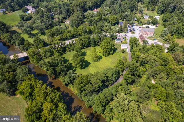 an aerial view of residential house with outdoor space and trees all around
