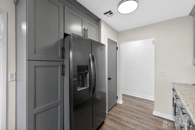 a metallic refrigerator freezer sitting in a kitchen