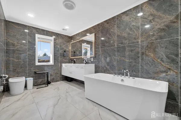 a bathroom with a double vanity sink a mirror and a bathtub