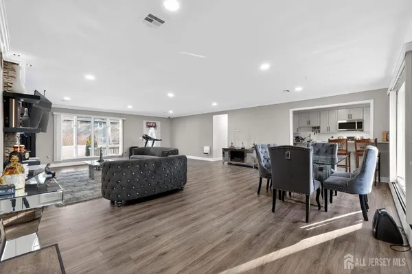 a living room with furniture a dining table and wooden floor