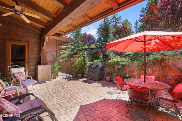 a view of a chairs and tables in the patio next to a yard