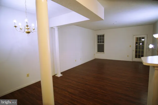 a view of a livingroom with an empty space and wooden floor