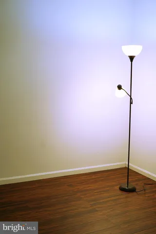 an empty room with wooden floor chandelier fan and windows