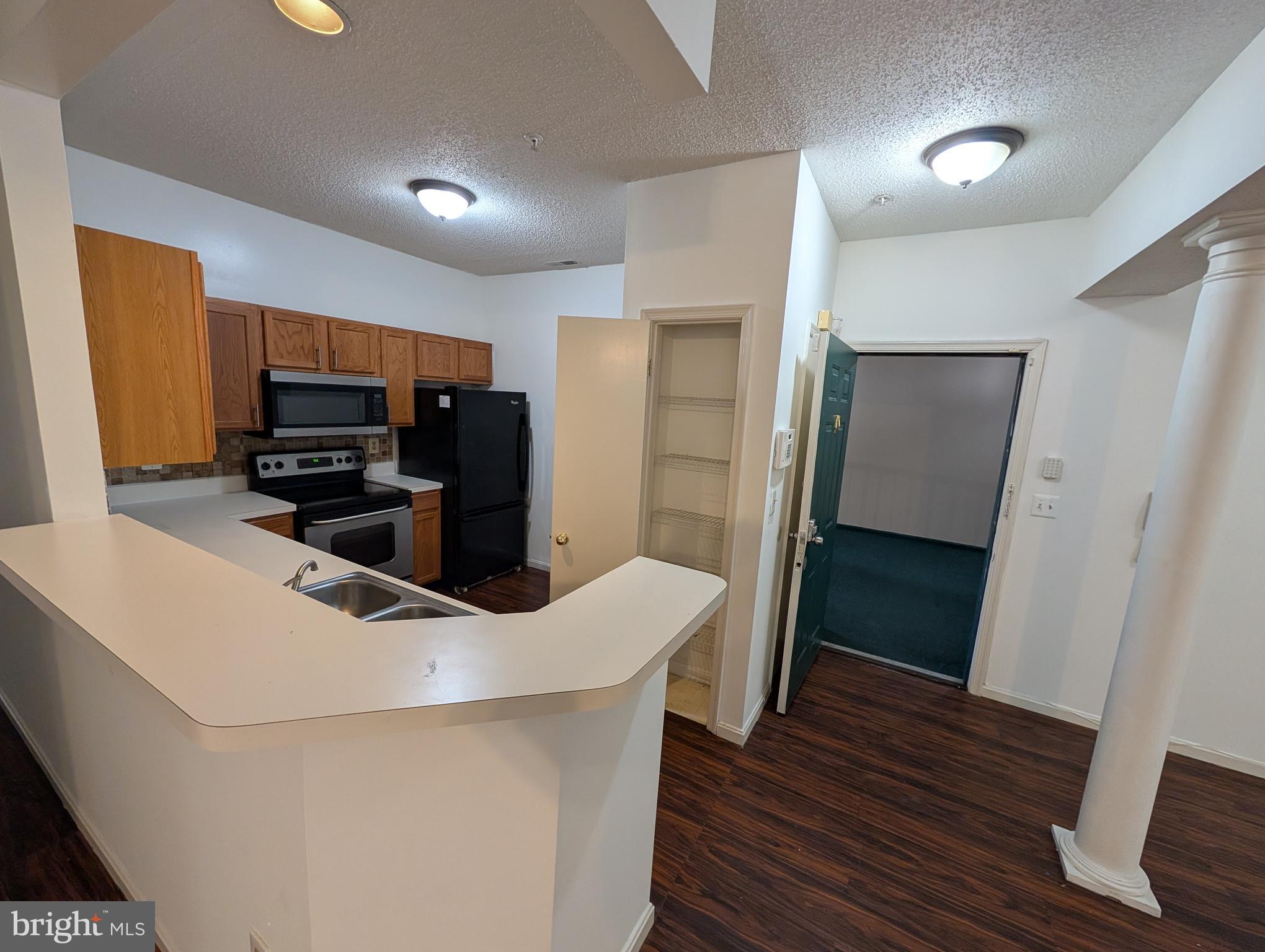 7115 Sandown Circle, Unit 202 Windsor Mill, MD 21244 - Photo 58 of 60 a kitchen with stainless steel appliances a refrigerator stove microwave and sink