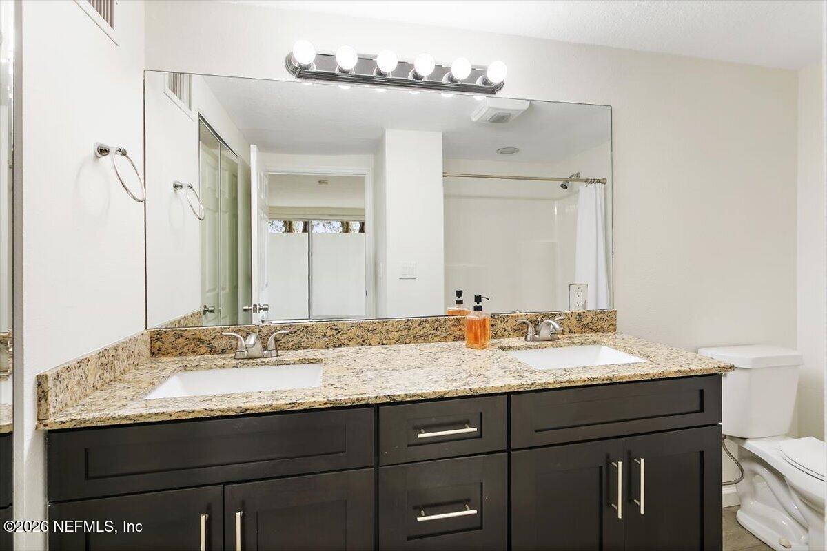 103 Coronado Street St. Augustine, FL 32080 - Photo 14 of 25 a bathroom with a granite countertop sink and a mirror