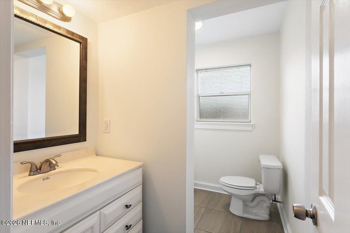 103 Coronado Street St. Augustine, FL 32080 - Photo 17 of 25 a bathroom with a granite countertop toilet sink and mirror