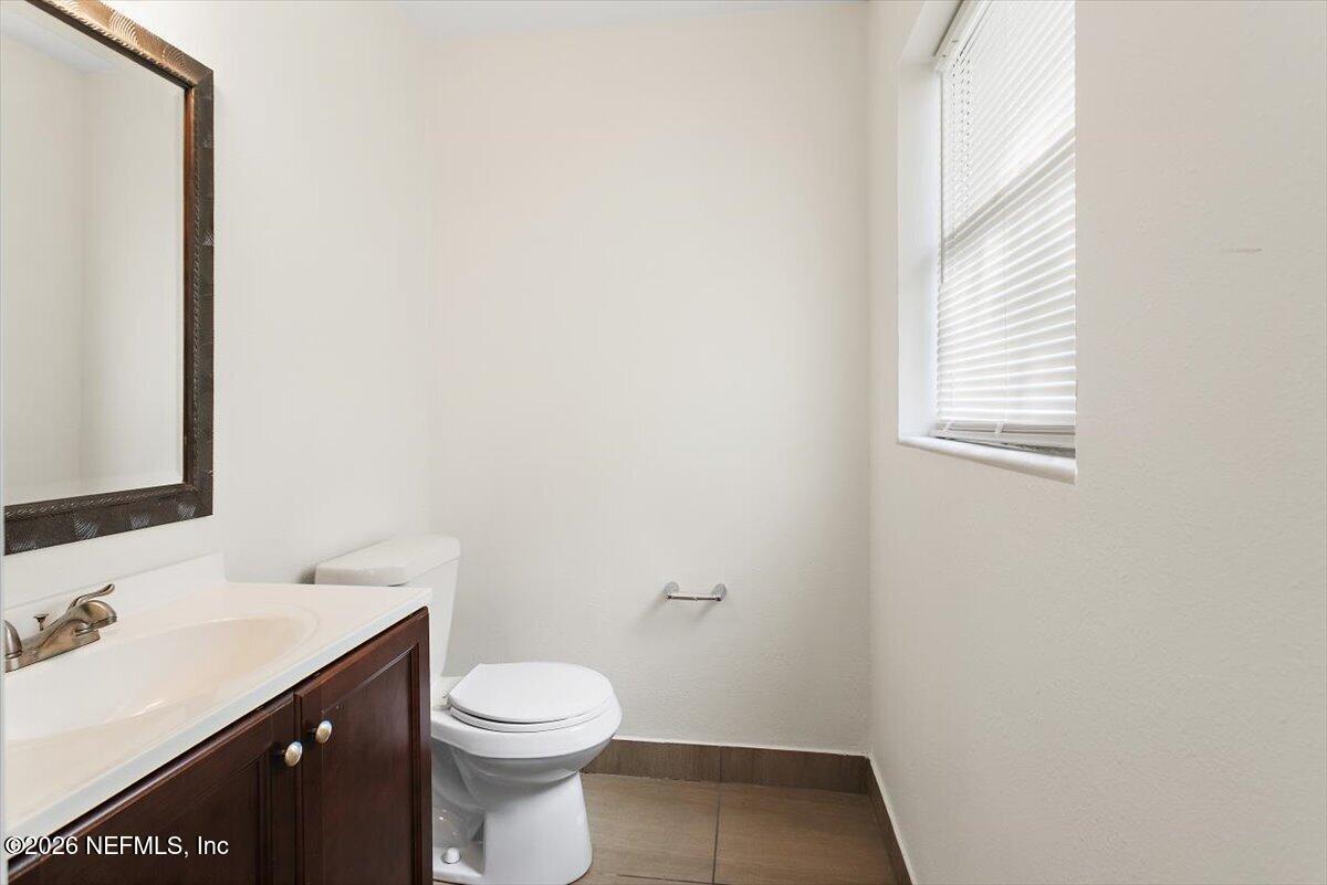 103 Coronado Street St. Augustine, FL 32080 - Photo 21 of 25 a bathroom with a sink a toilet and a mirror