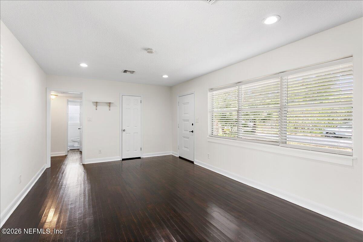 103 Coronado Street St. Augustine, FL 32080 - Photo 3 of 25 an empty room with wooden floor and windows