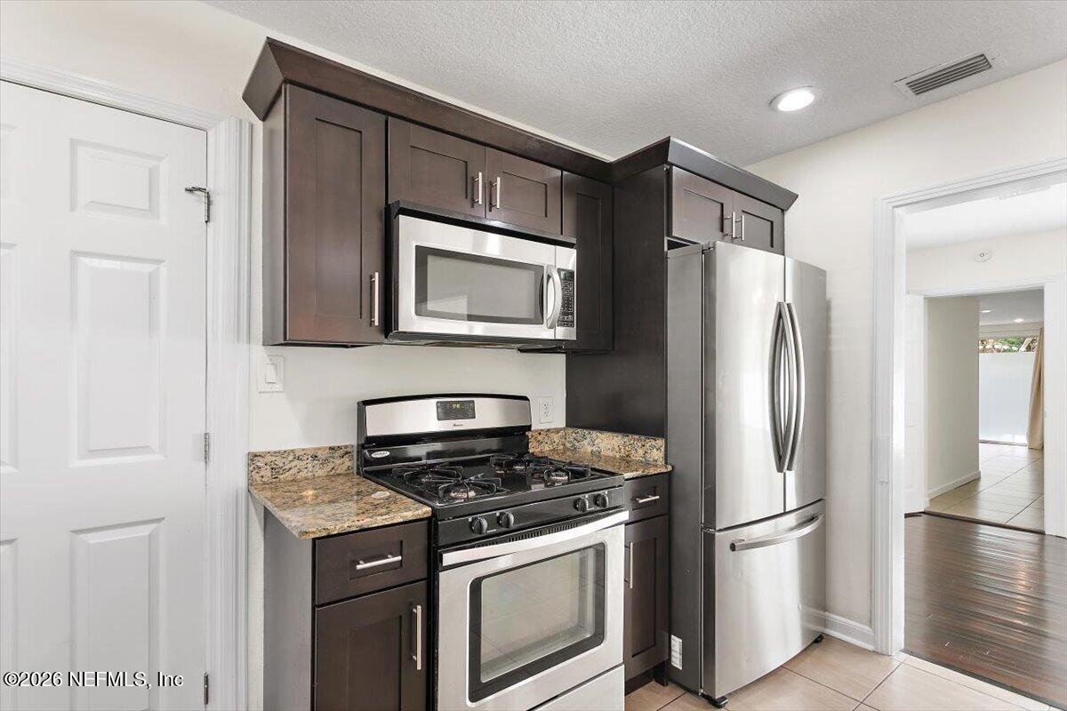 103 Coronado Street St. Augustine, FL 32080 - Photo 8 of 25 a kitchen with stainless steel appliances granite countertop a refrigerator stove and microwave