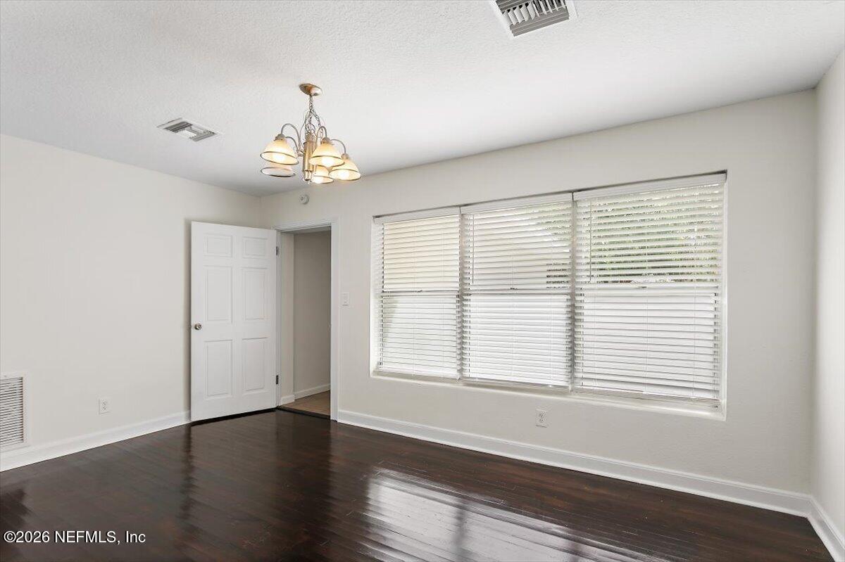 103 Coronado Street St. Augustine, FL 32080 - Photo 10 of 25 a view of an empty room with wooden floor and a window