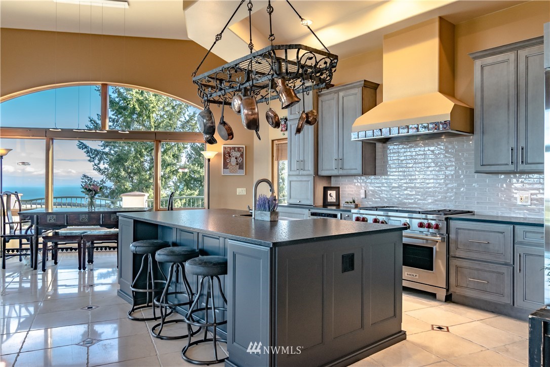 335 Quails Roost Road Sequim, WA 98382 - Photo 14 of 40 a kitchen with a sink a cabinets and chairs