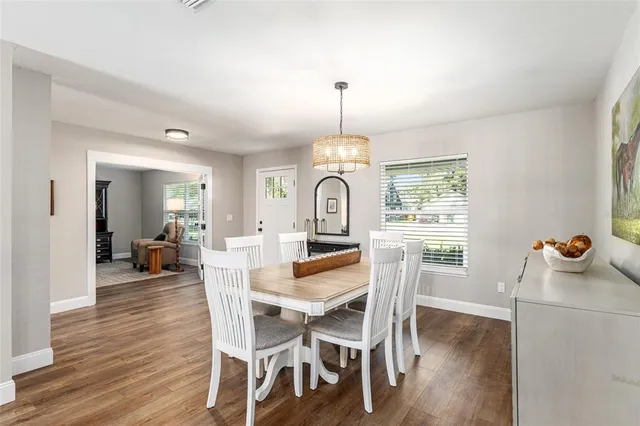 a kitchen with stainless steel appliances kitchen island granite countertop a table chairs stove and refrigerator