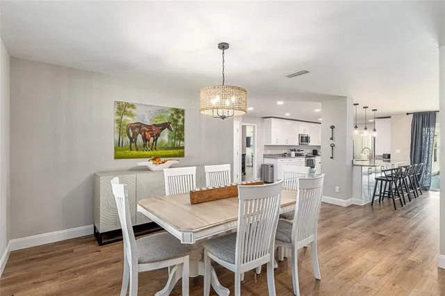 a large kitchen with stainless steel appliances granite countertop a lot of counter space and wooden floors