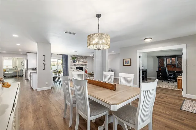 a kitchen with granite countertop a sink dishwasher stove and white cabinets with wooden floor
