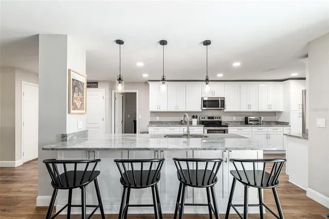a kitchen with stainless steel appliances granite countertop a refrigerator and a sink