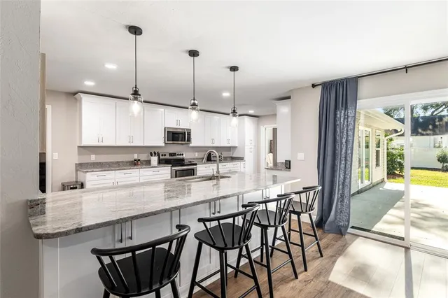 a living room with furniture a large window and a ceiling fan