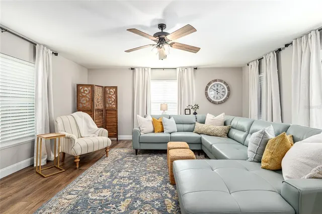 a view of a hallway with wooden floor windows and a living room