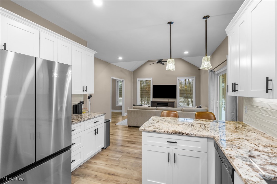 39600 Aurora Road Solon, OH 44139 - Photo 17 of 49 Kitchen with decorative backsplash, freestanding refrigerator, ceiling fan, vaulted ceiling, and pendant lighting