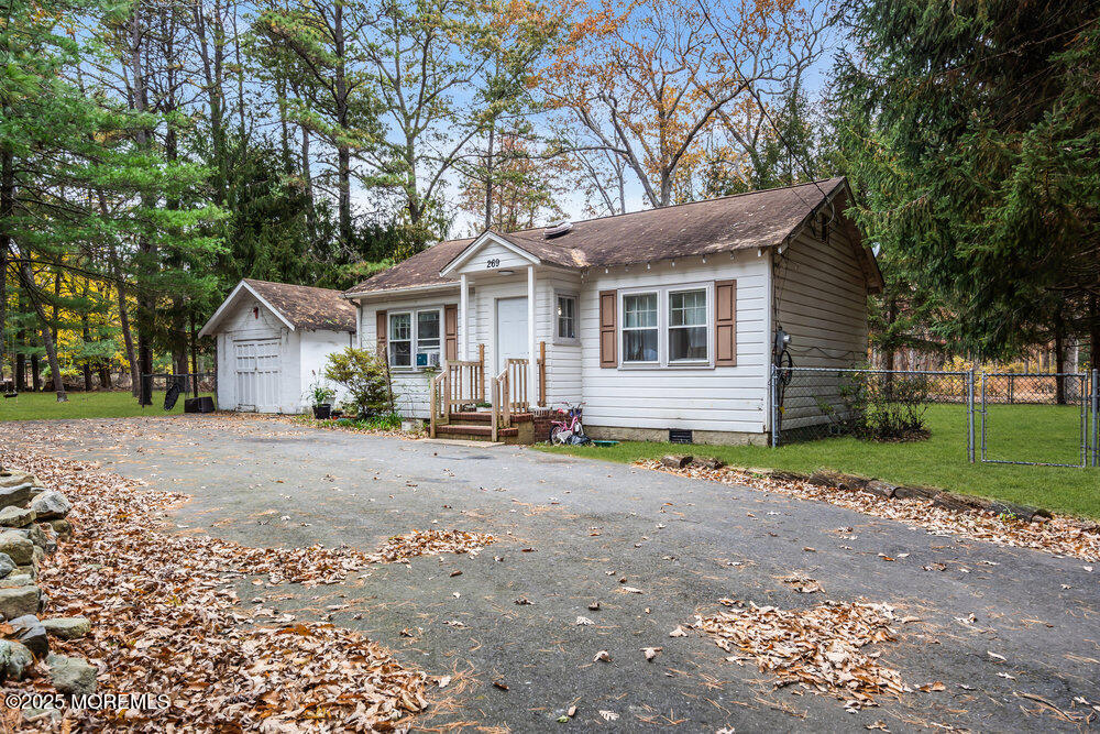 a view of a house with a yard and large trees