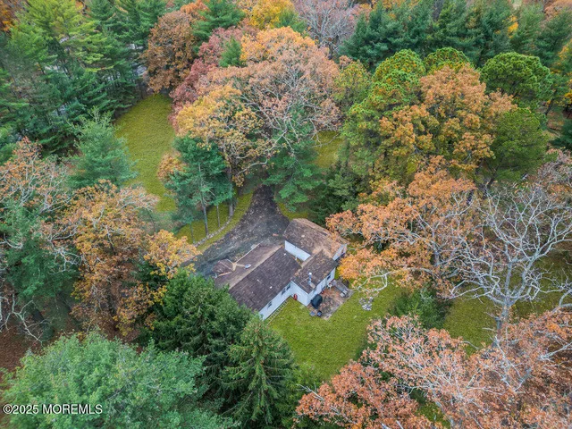 an aerial view of residential houses with outdoor space and trees all around