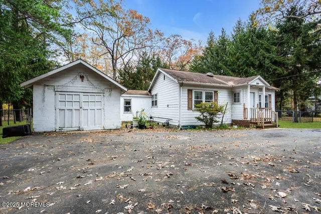 a view of a house with a yard and large tree