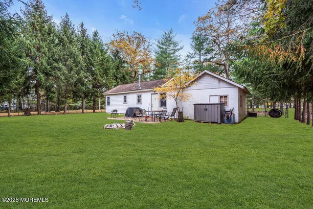 a view of a house with a big yard potted plants and large tree