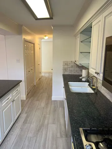 a view of a kitchen with wooden floor and cabinets