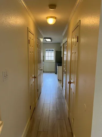 a view of a hallway with wooden floor