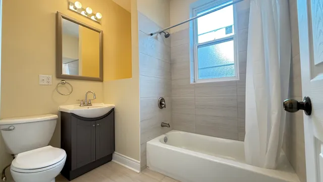 a bathroom with a sink a mirror toilet and bathtub