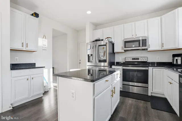a kitchen with stainless steel appliances granite countertop a stove and a refrigerator