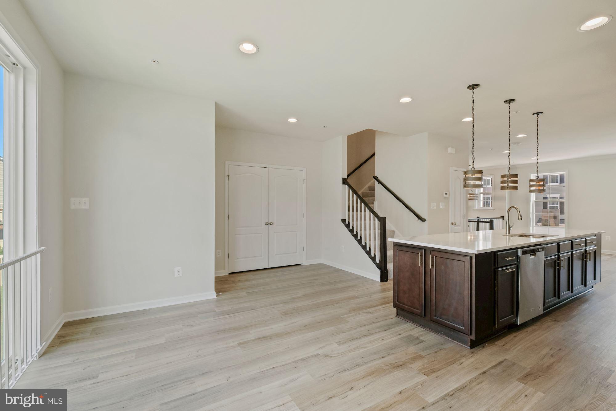 6211 Davinci Street Frederick, MD 21703 - Photo 13 of 30 a view of an empty room with wooden floor and stairs