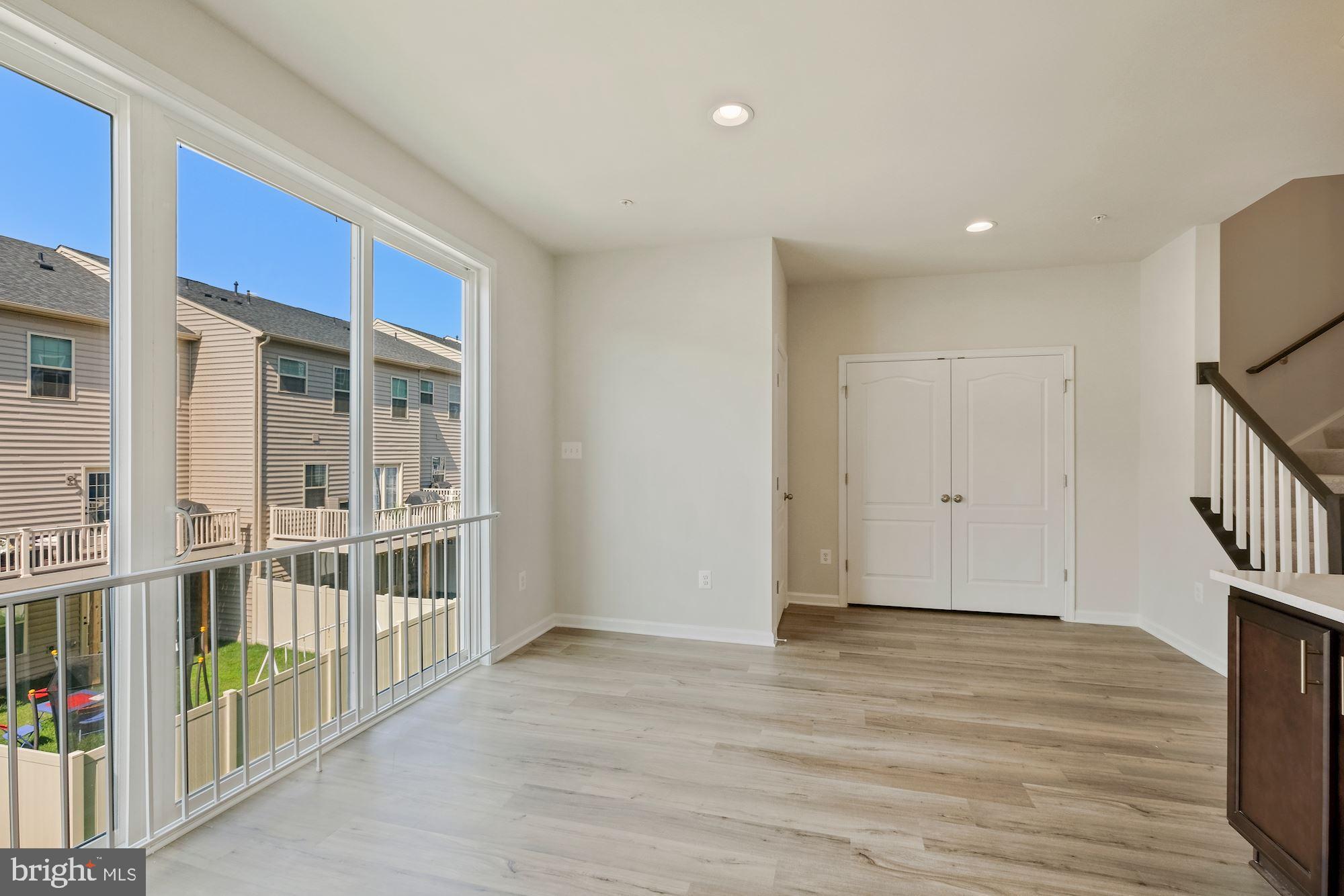 6211 Davinci Street Frederick, MD 21703 - Photo 14 of 30 a view of an empty room with wooden floor and a window