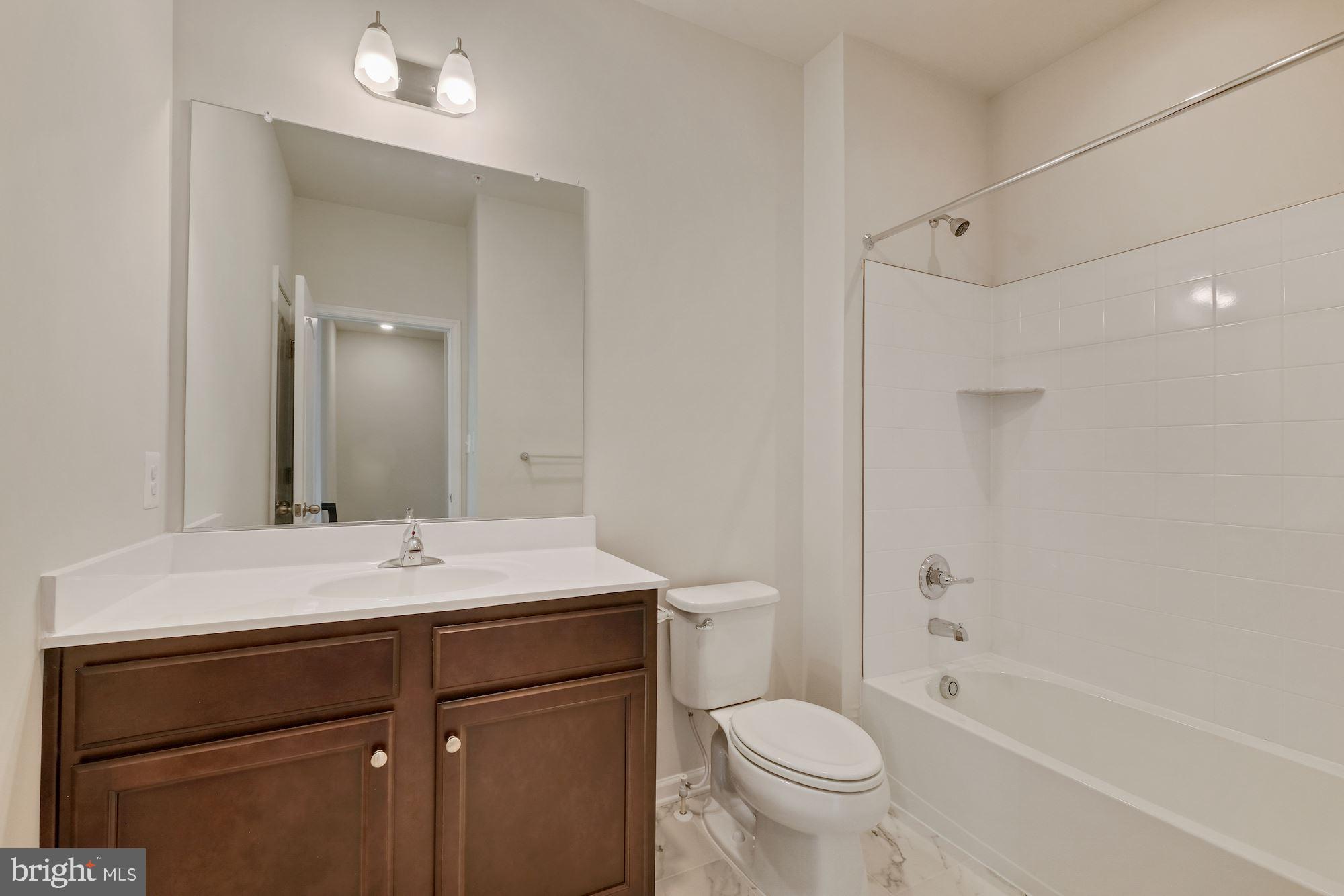 6211 Davinci Street Frederick, MD 21703 - Photo 23 of 30 a bathroom with a sink toilet vanity and shower