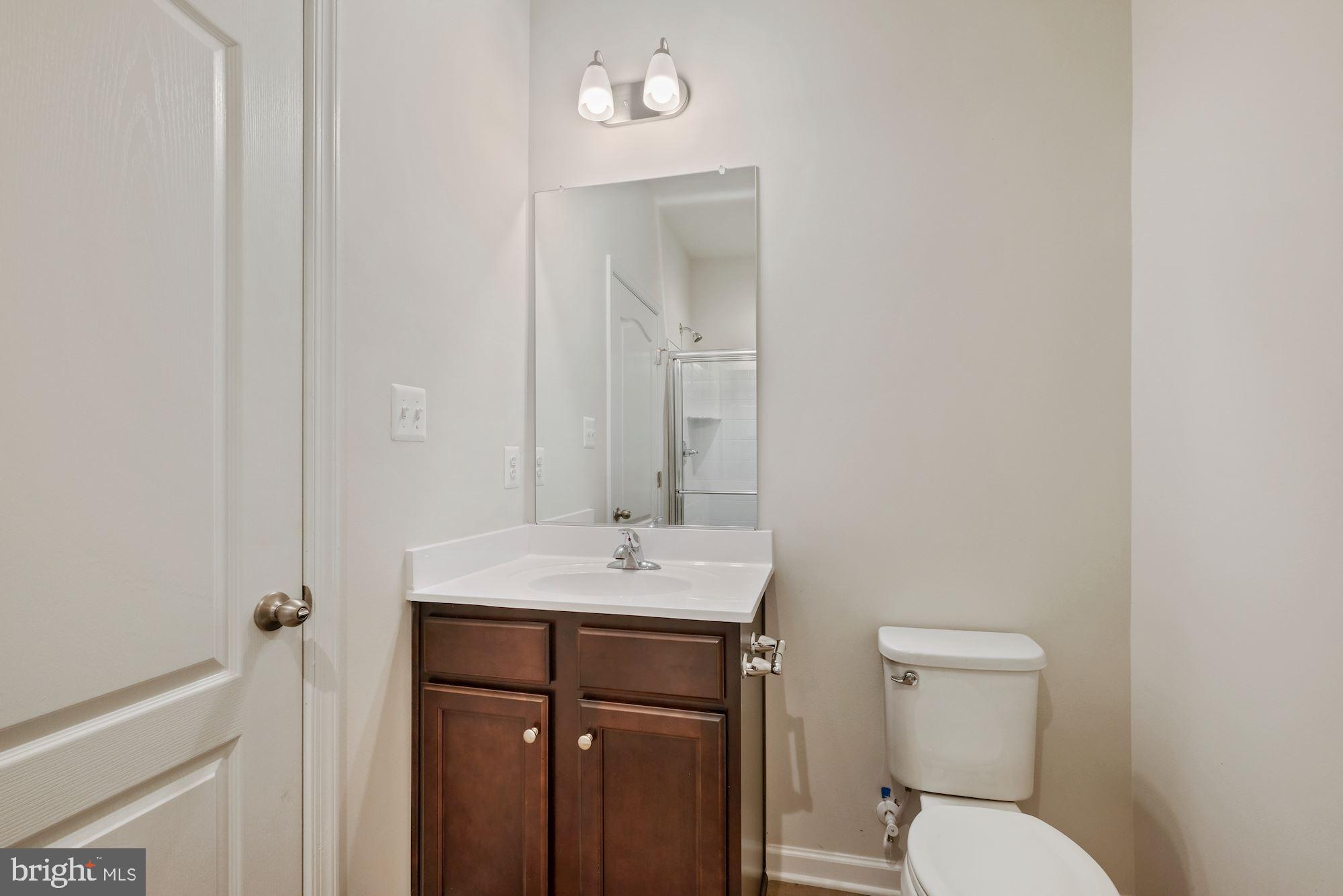 6211 Davinci Street Frederick, MD 21703 - Photo 29 of 30 a bathroom with a toilet a sink and mirror