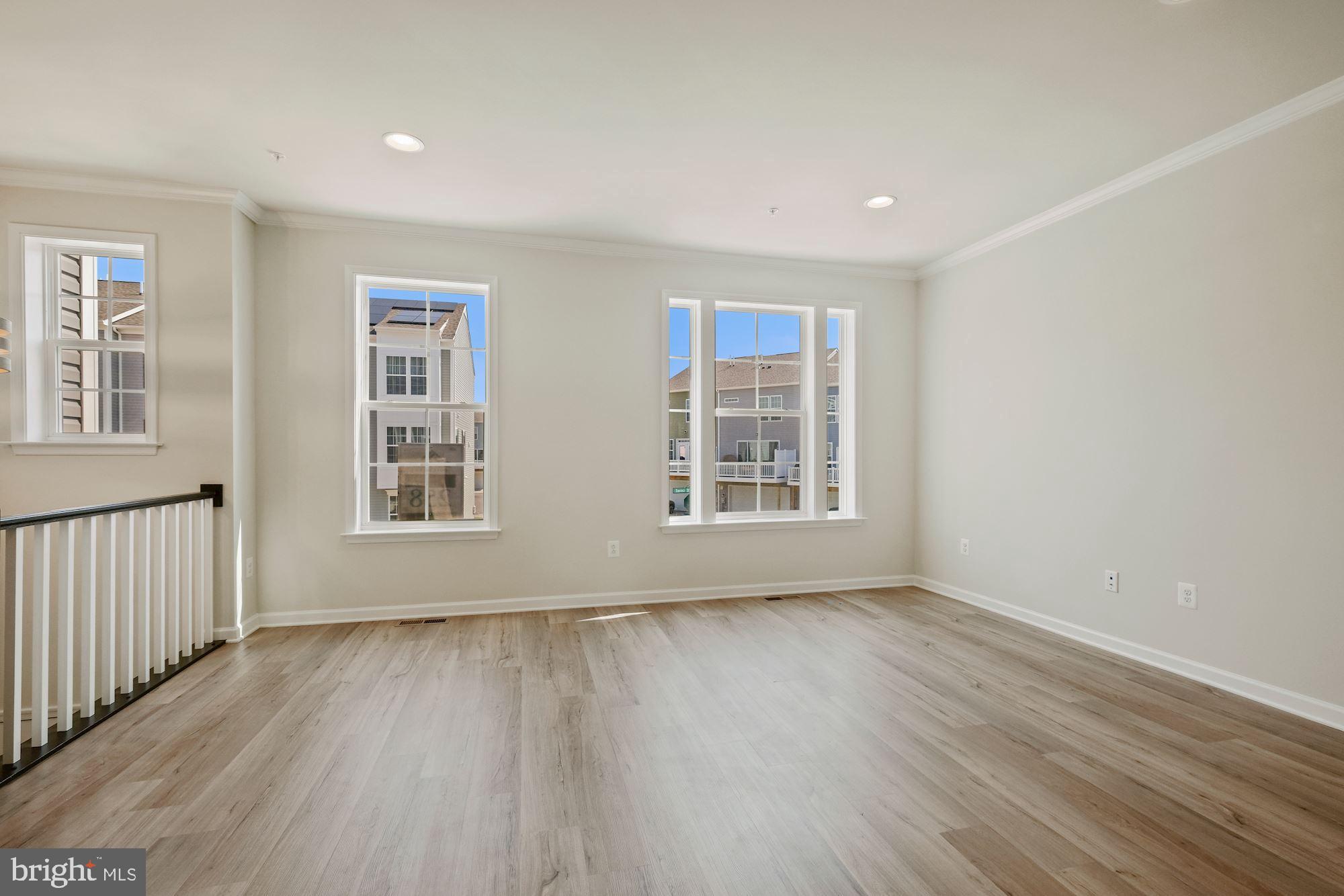 6211 Davinci Street Frederick, MD 21703 - Photo 5 of 30 a view of an empty room with wooden floor and a window