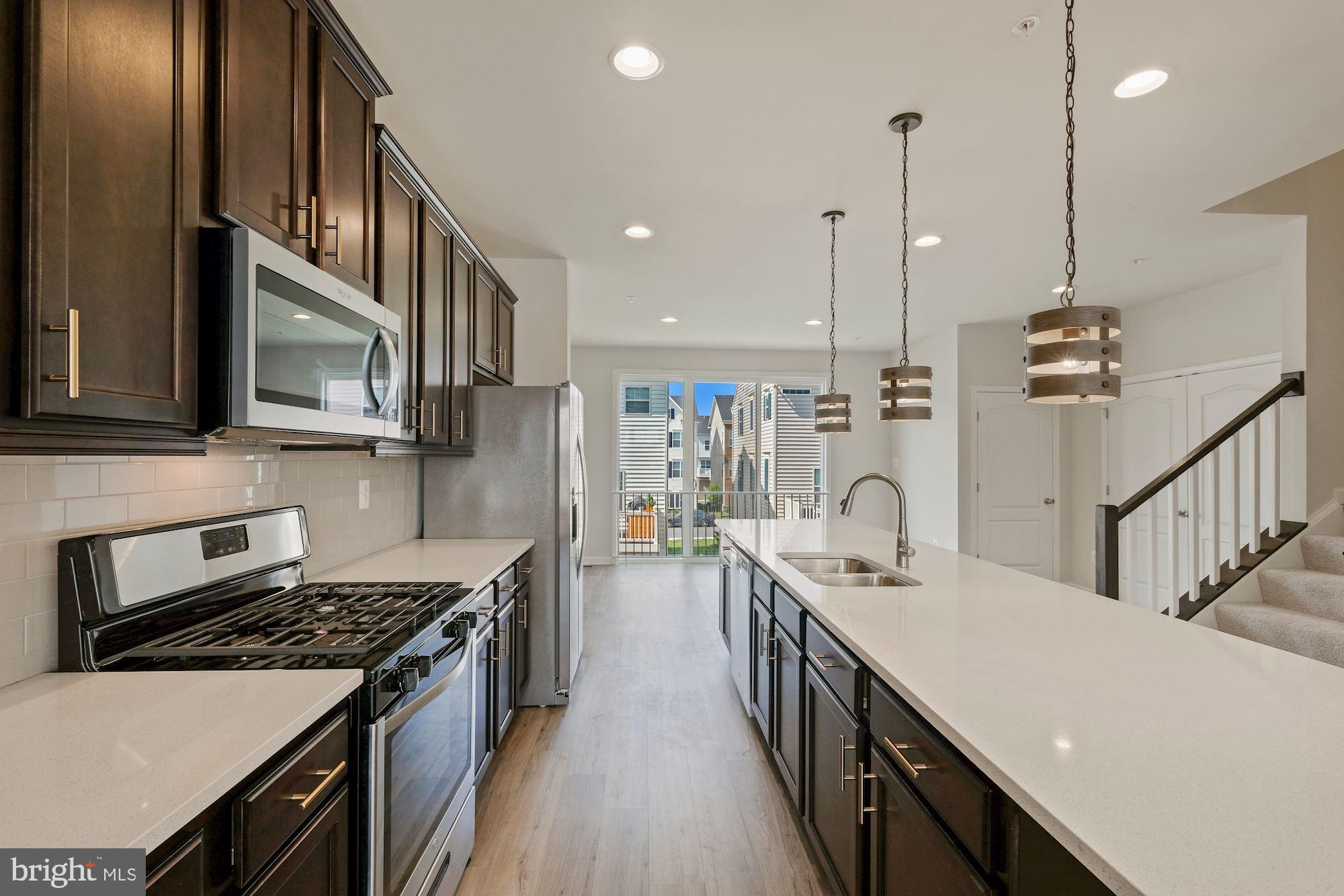 6211 Davinci Street Frederick, MD 21703 - Photo 8 of 30 a kitchen with stainless steel appliances granite countertop a sink a stove and a wooden floors