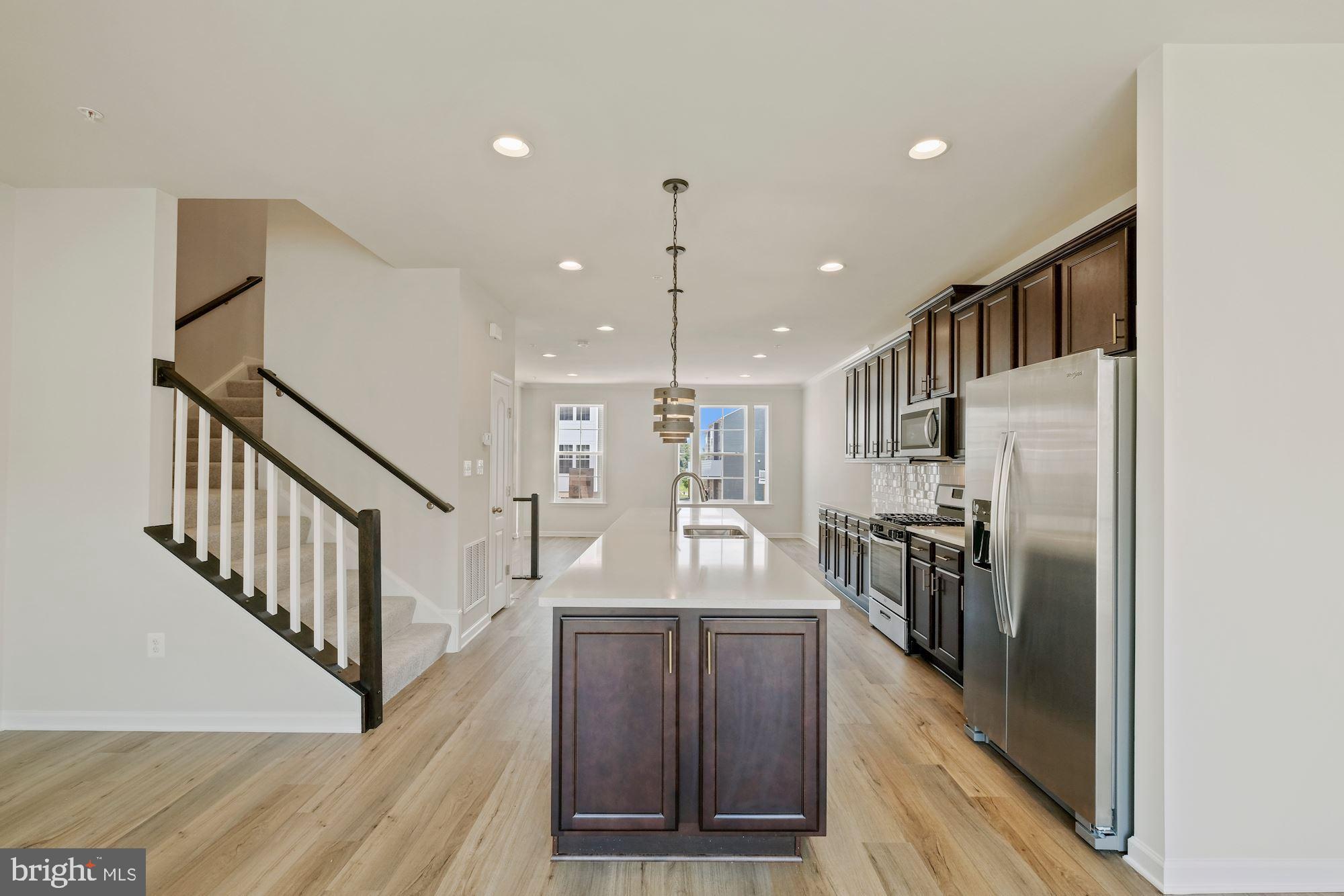 6211 Davinci Street Frederick, MD 21703 - Photo 9 of 30 a view of a kitchen with kitchen island wooden floor center island and stainless steel appliances