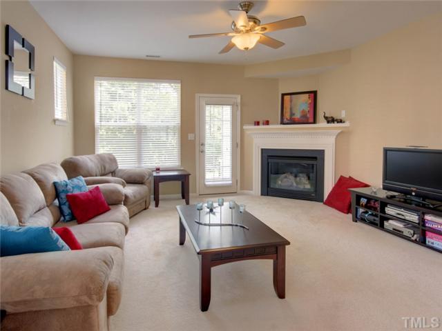 8434 Central Drive Raleigh, NC 27613 - Photo 3 of 25 a living room with furniture a flat screen tv and a fireplace