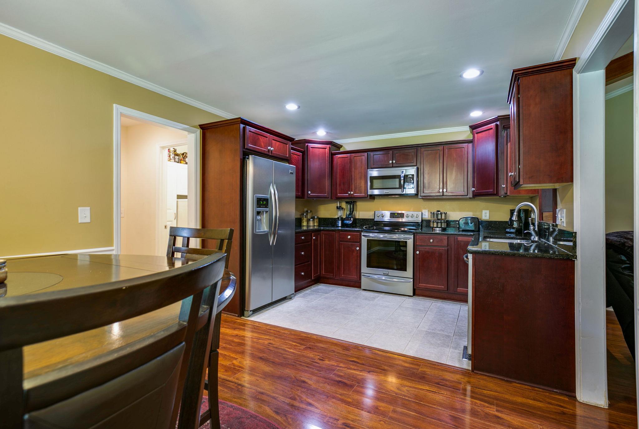 1649 Deerrun Road Murfreesboro, TN 37129 - Photo 21 of 28 a kitchen with stainless steel appliances kitchen island granite countertop a stove a refrigerator and a wooden cabinets