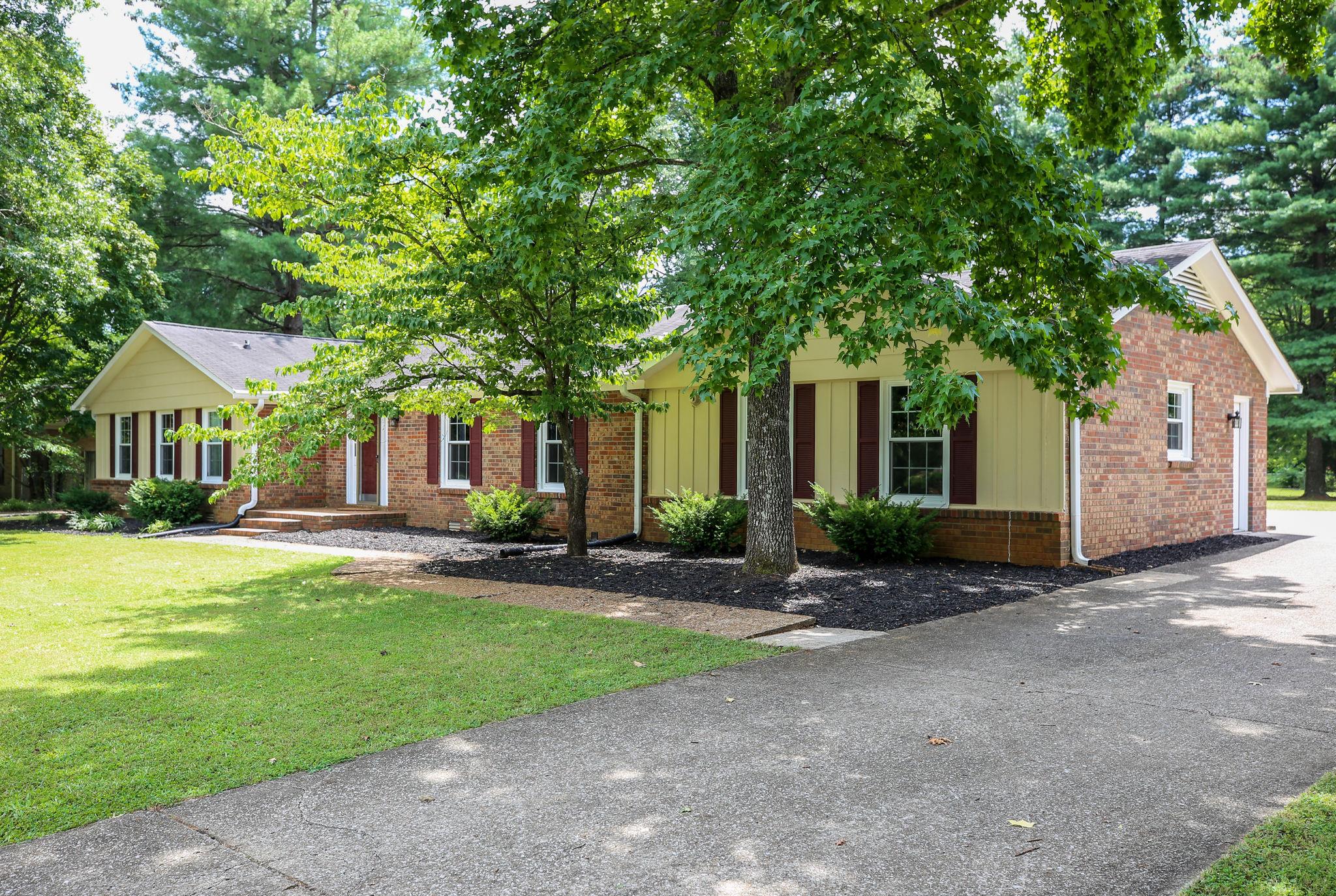 1649 Deerrun Road Murfreesboro, TN 37129 - Photo 3 of 28 a front view of a house with a yard and garage