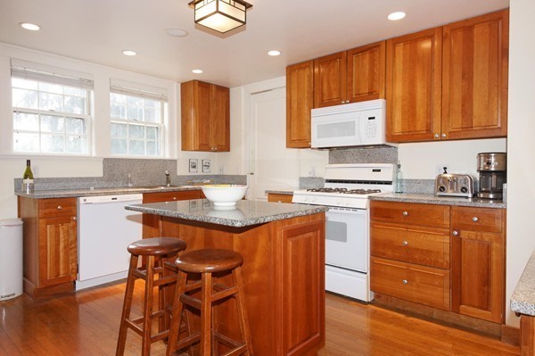 19 Highland Road Belmont, MA 02478 - Photo 5 of 30 a kitchen with stainless steel appliances granite countertop a stove a sink dishwasher and a refrigerator with wooden cabinets